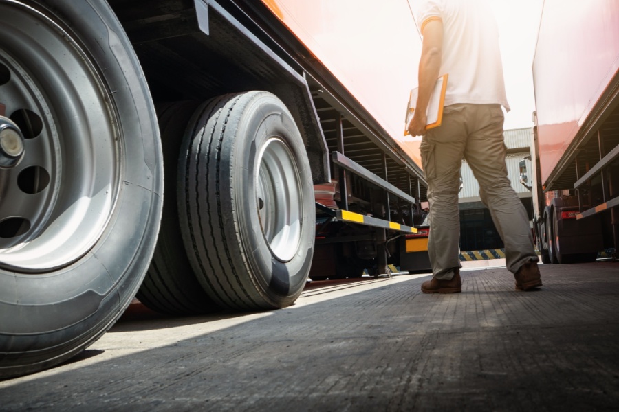 A fleet owner is seen investing in used trucks by purchasing a batch from a dealer and shaking the hand of a salesman