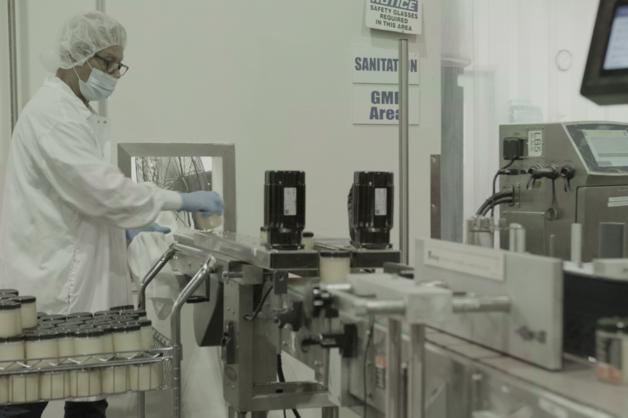 worker assembling product sample packages in co-packing facility